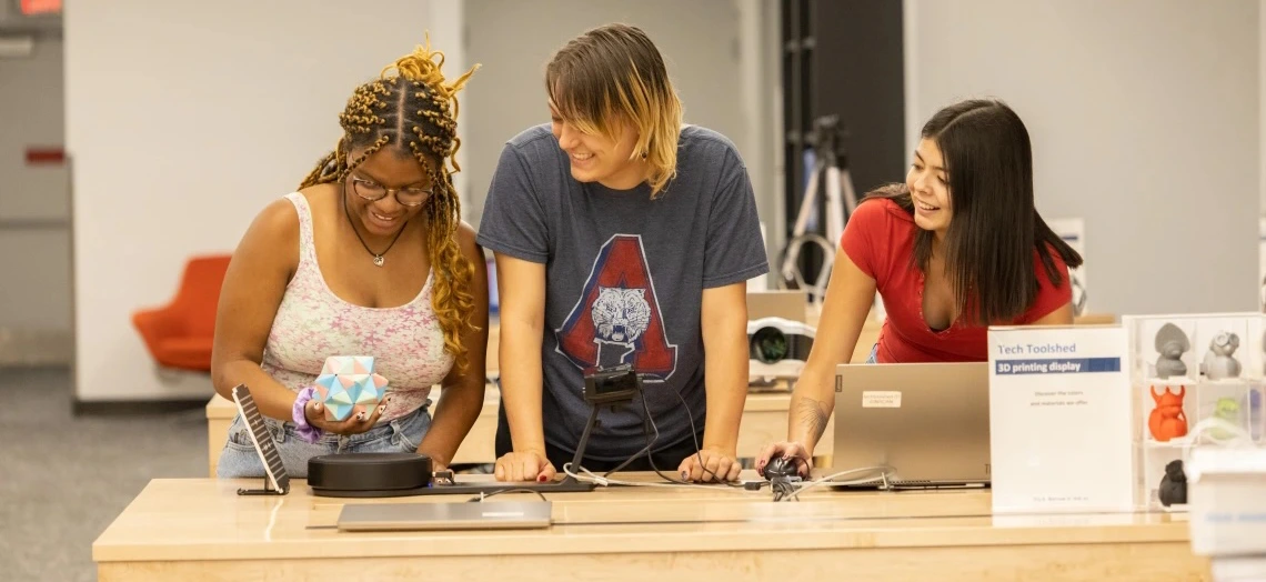 Three students creating in a maker space.