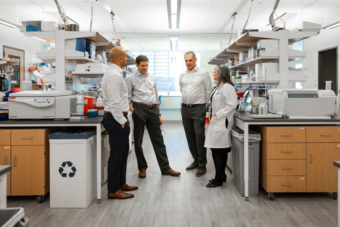 The four members of the Aspiro team standing in a lab talking with one another.