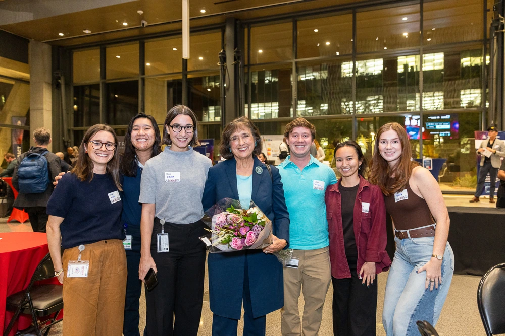 Inventor of the Year Robbie Brinton holds a bouquet of flowers and poses with those who came to celebrate her accomplishment.