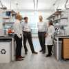 The four members of the Aspiro team standing in a lab talking with one another. 